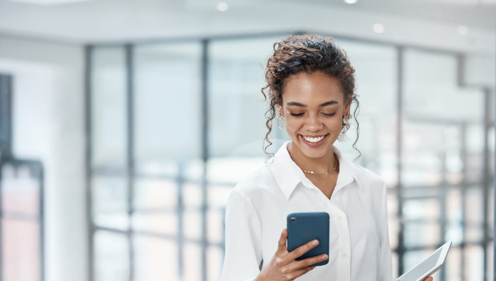 Cropped shot of an attractive young businesswoman sending a text while working in her office