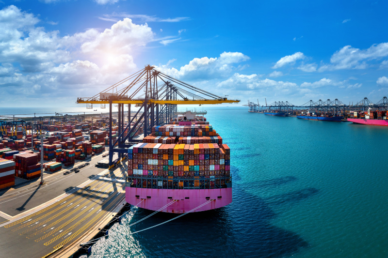 Aerial view of cargo ship and cargo container in harbor.